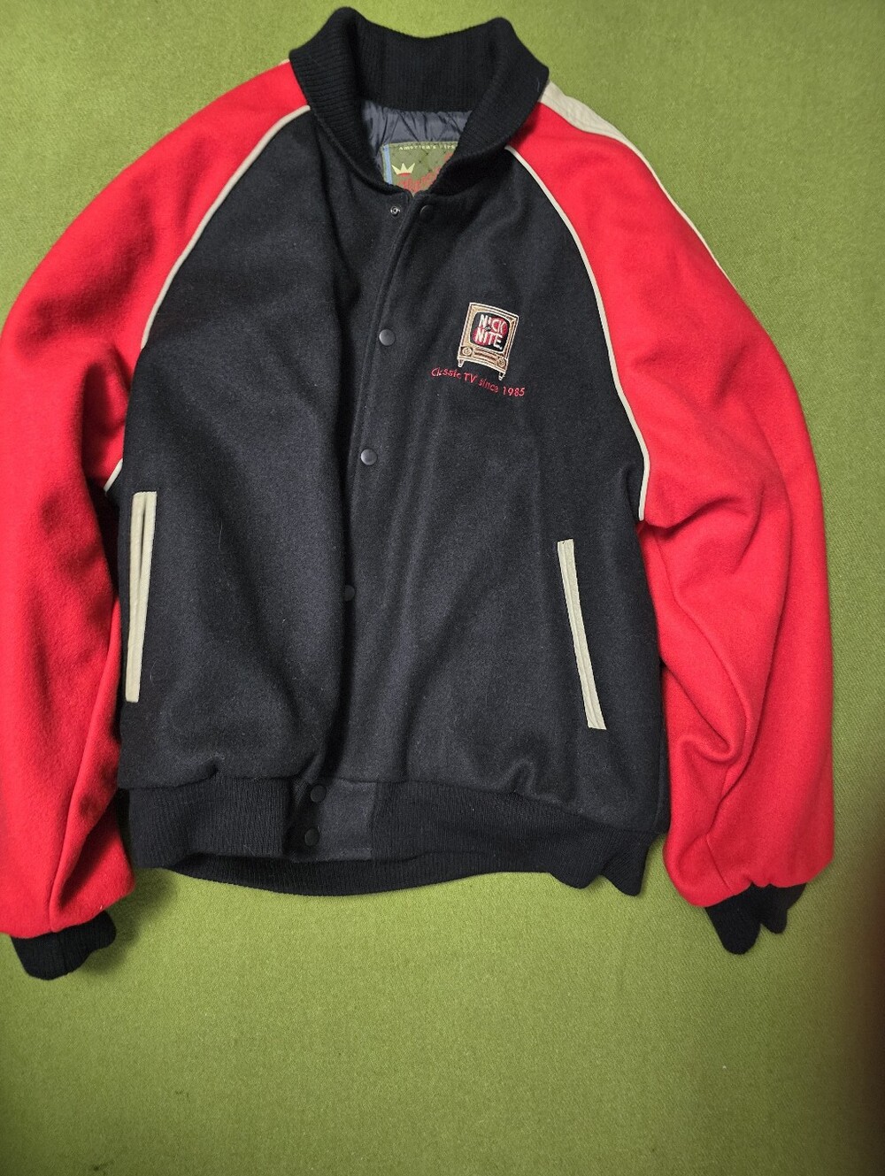 Black and red varsity jacket features embroidered "Nick at Nite" branding.